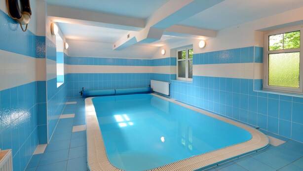 A swimming pool with blue and white tiles, a window with a view of greenery, and a ceiling with recessed lighting. - Albrechtice Laq016 in Albrechtice v Jizersk ch hor ch (Albrechtice v Jizerských horách)