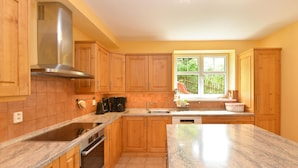 A kitchen with wooden cabinets, granite countertops, a stainless steel range hood, and a window with a view of greenery outside. - Albrechtice Laq016 in Albrechtice v Jizersk ch hor ch (Albrechtice v Jizerských horách)