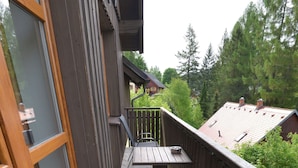 A balcony with a wooden railing, a metal table, and a metal chair. - Albrechtice Laq016 in Albrechtice v Jizersk ch hor ch (Albrechtice v Jizerských horách)