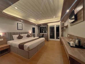 Ein modernes Hotelzimmer mit einem großen Bett, einem Schreibtisch und einem Balkon mit Blick.