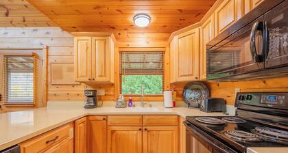 Sunny riverside cabin with loft views, big deck, game room, porches, and open lawn.