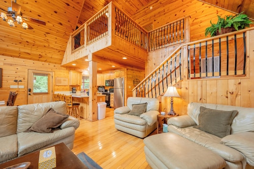 Sunny riverside cabin with loft views, big deck, game room, porches, and open lawn.