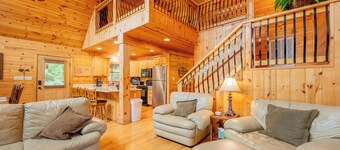Sunny riverside cabin with loft views, big deck, game room, porches, and open lawn.