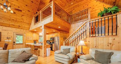 Sunny riverside cabin with loft views, big deck, game room, porches, and open lawn.