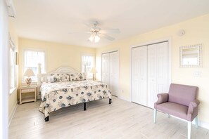 A bedroom with a bed, a chair, a ceiling fan, and a wardrobe. - Seas The Moment - 2nd Row, 4 BR Home with Covered Porches (Surf City)