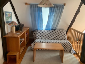 A cozy room with a wooden bench, a small table, a bookshelf, and a window with curtains. - Apartment "Swallow's Nest" with Shared Garden and Wi-Fi (Trebel)