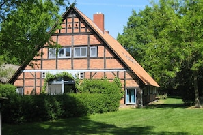 A traditional half-timbered house with a sloped roof, surrounded by lush greenery and trees. - Apartment "Swallow's Nest" with Shared Garden and Wi-Fi (Trebel)