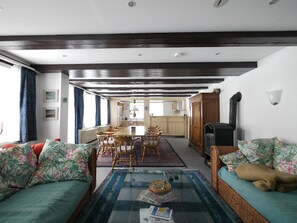 A living room with a sofa, a coffee table, and a dining area with chairs and a table. - Apartment "Teichblick" with Private Terrace, Shared Garden and Wi-Fi (Trebel)