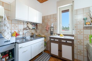 A kitchen with white cabinets, a built-in sink, and a window with a view.