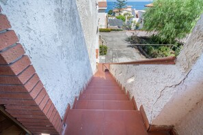 A staircase leading to a residential area with a view of the sea.
