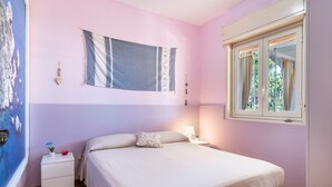 A bedroom with a bed, bedside table, lamp, and a window with curtains. - Casa Orchidea with Veranda – Private Terrace, Wi-Fi & Air Conditioning (Costa Saracena - Castelluccio)