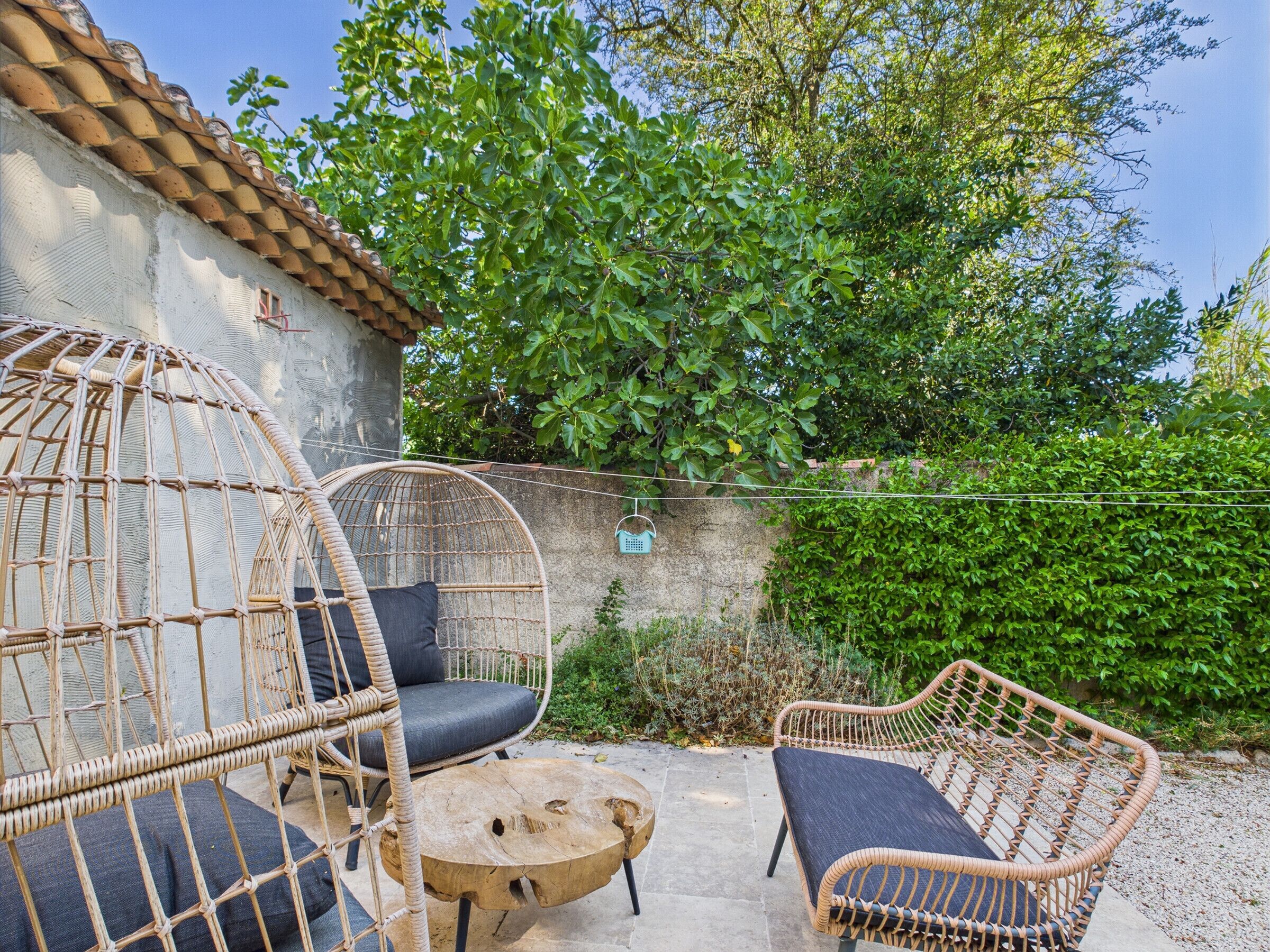 A patio with wicker furniture, including two chairs and a small table.