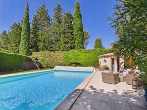 A rectangular swimming pool with a clear blue water surface, surrounded by a paved deck.