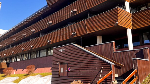 Un edificio de varios pisos con diseño moderno, con balcones y ventanas grandes.