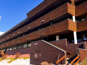 A multi-story building with a modern design, featuring balconies and large windows.