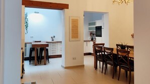 A modern kitchen with white cabinets, a black oven, and a dining area with wooden chairs and a table.