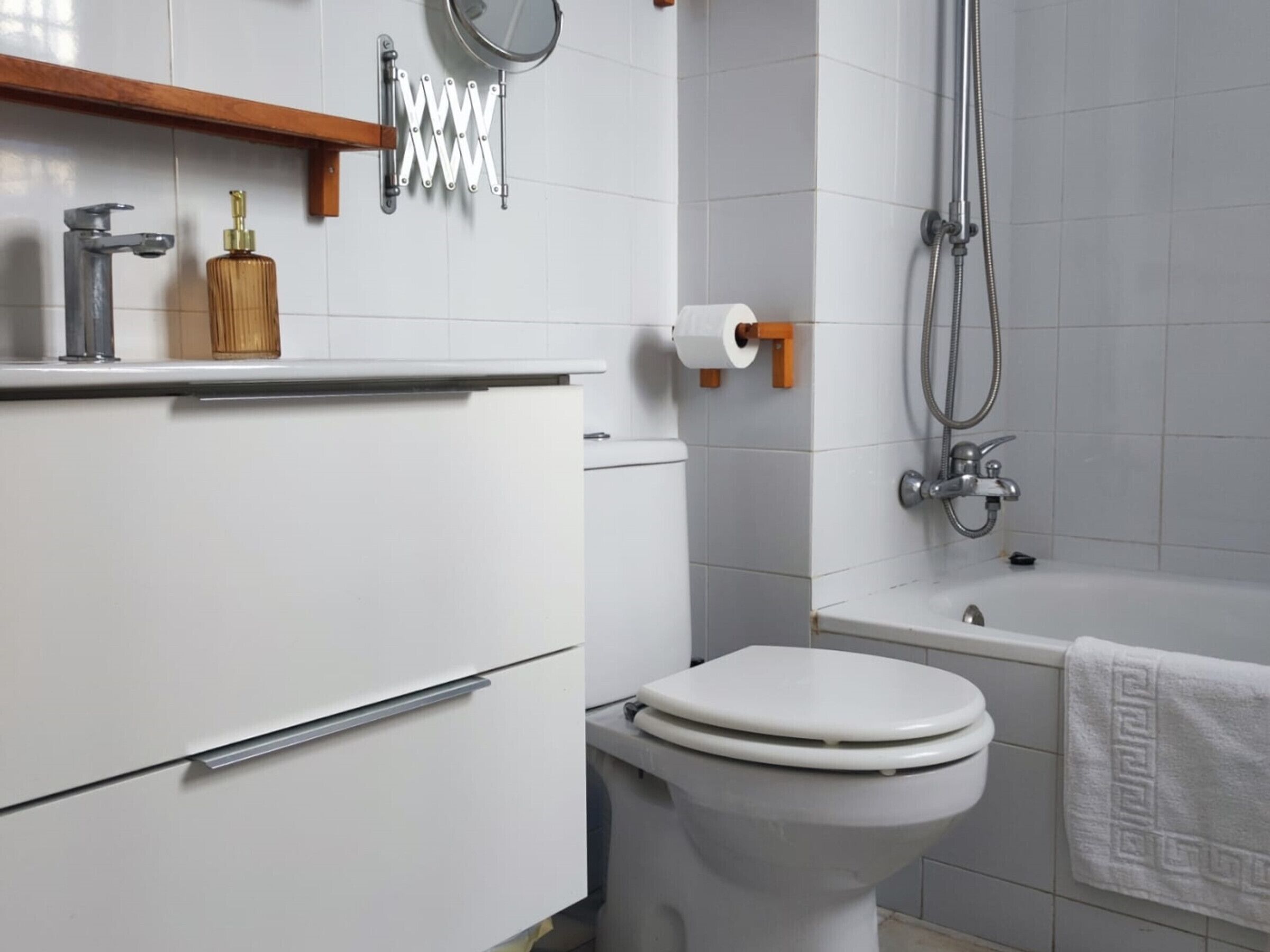 A modern bathroom with a toilet, sink, and shower.