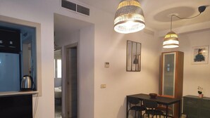 Un soggiorno moderno con TV, tavolino in legno e zona pranzo con tavolo e sedie.