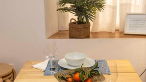 A dining table with a white bowl, a glass, and a basket of oranges. - Beautiful apartment in Seville's historic center (Sevilla)