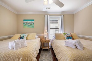A hotel room with two beds, a window with curtains, a painting on the wall, and a small table with a lamp. - Spacious 3BR Getaway with BBQ, close to Beach (North Myrtle Beach)