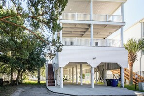 A multi-story building with a covered porch and a staircase leading to the upper levels.