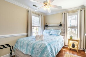A bedroom with a bed, a ceiling fan, a nightstand, and a window with curtains. - Spacious 3BR Getaway with BBQ, close to Beach (North Myrtle Beach)