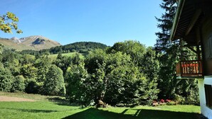 A view of a mountain landscape with a building in the foreground. - 6-person apartment in quiet chalet near slopes (Le Grand-Bornand)