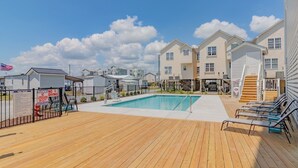 Un espace piscine doté d’une terrasse en bois, d’un plongeoir et d’un poste de surveillance pour les sauveteurs.