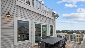 Une terrasse avec une table et des chaises, donnant sur un quartier résidentiel.