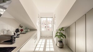 A modern kitchen with a toaster, kettle, and potted plant. - S O Bento Modern by Homing (Lisbon)
