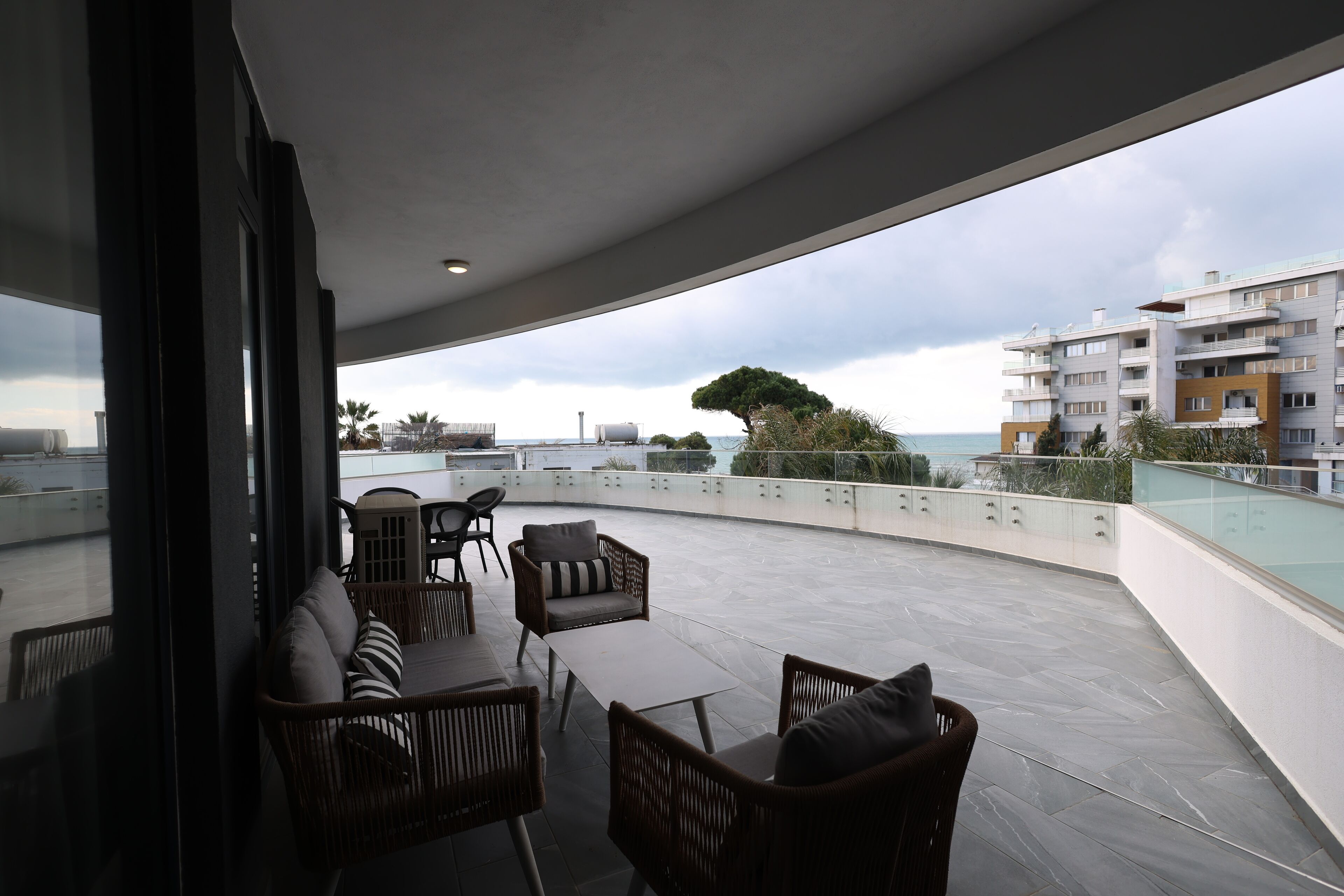 A rooftop terrace with outdoor furniture, a pool, and a view of the cityscape.