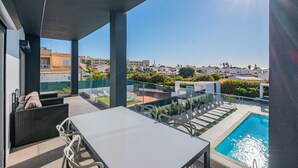 Une terrasse sur le toit avec une piscine, des espaces de détente en plein air et une vue dégagée sur les bâtiments environnants.