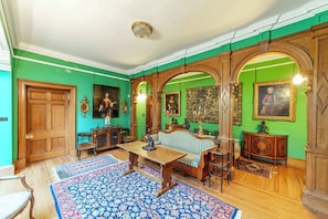 Una habitación con piso de madera, un sofá, una mesa y un tapete estampado.