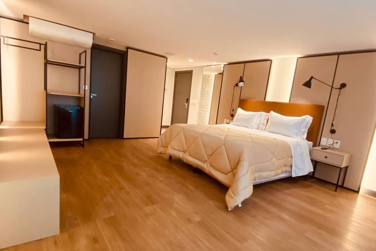 A bedroom with a bed, bedside tables, a wardrobe, and a built-in shelf unit.