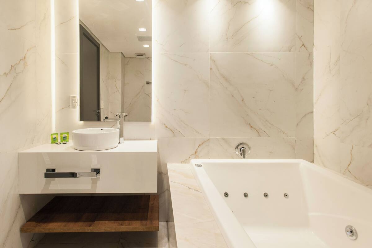 A modern bathroom with a freestanding bathtub, a vanity with a sink, and a large mirror.