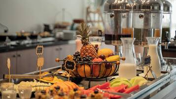 Un bufé con una variedad de frutas, verduras y bebidas.