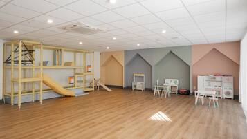 Ein Spielzimmer mit Rutsche, Spielbereich und Kinderzimmermöbeln.