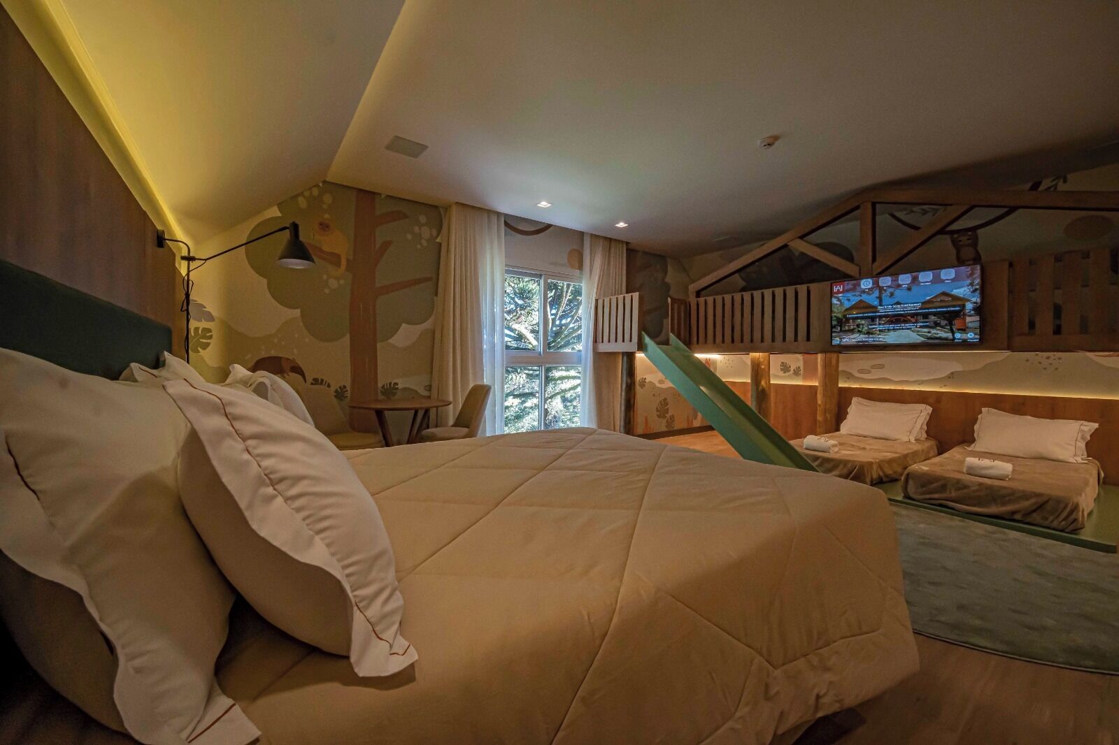 Quarto de hotel com uma cama grande, uma mesa e uma televisão.