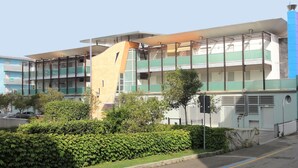 A multi-story building with a modern architectural design, featuring balconies and large windows.
