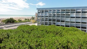 Een modern gebouw met meerdere balkons met uitzicht op een strand.