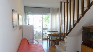 Ein kompakter Wohnbereich mit Küchenzeile, Essbereich und Treppe.