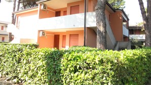Un edificio de dos plantas con techo plano y un balcón en el piso superior.