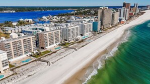 Ein Hotel an der Küste mit mehreren Gebäuden, einem Strand und Blick aufs Meer.