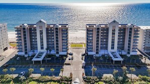 Ein Hochhaus-Hotel mit Innenhof, Parkplatz und Blick aufs Meer.