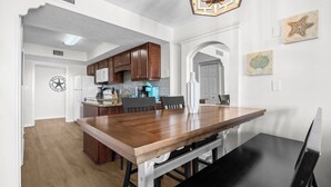 Eine moderne Küche mit dunklen Holzausziehtüren, einem weißen Kühlschrank und einer blauen Arbeitsplatte.