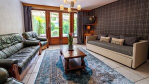 Ein Wohnzimmer mit einer Couch, einem Couchtisch und einem an der Wand befestigten Fernseher.