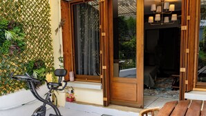 Ein Zimmer mit einer Schiebetür zu einem Balkon, einem Laufband und einem Holztisch.
