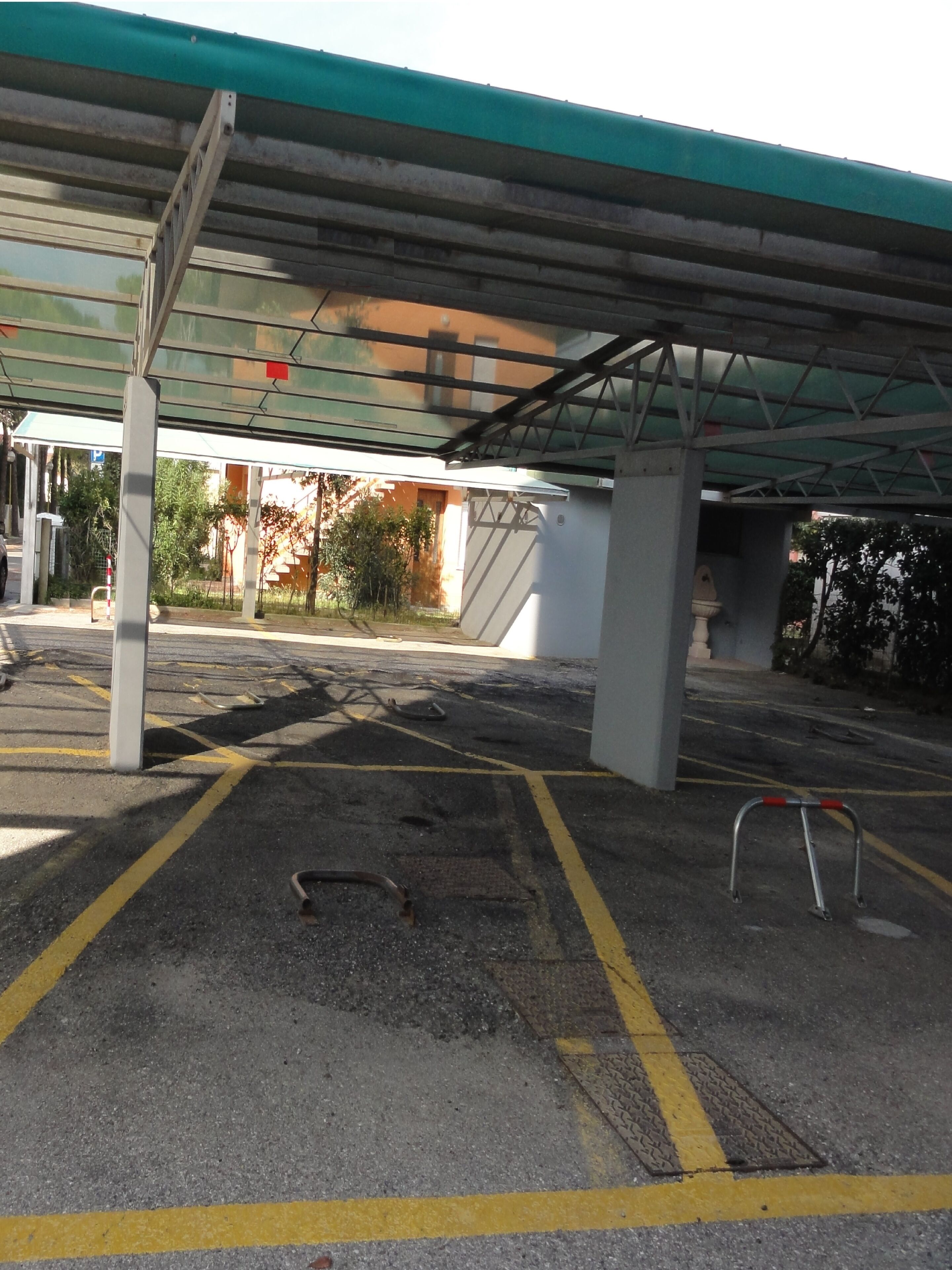 A parking area with yellow lines, a disabled parking sign, and a metal barrier.