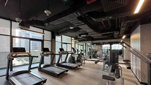 Ein Fitnessstudio mit Laufbändern, Crosstrainern und Kraftgeräten.