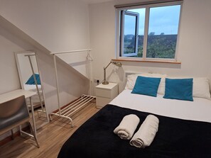 A bedroom with a bed, a desk, a chair, a window, and a radiator. - A Quiet House in a Nice Area (Cambridge)